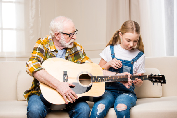 Grandfather and granddaughter with guitar    - Foto, afbeelding