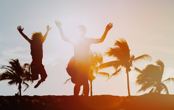 щаслива мати і син стрибають розважаючись на заході сонця
 - Фото, зображення