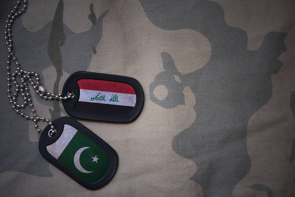 ejército en blanco, etiqueta de perro con bandera de Irak y Pakistán en el fondo de textura caqui. concepto militar
 - Foto, imagen