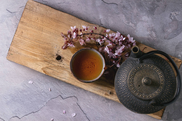 Teapot and cup of tea with blossom branch - Fotó, kép