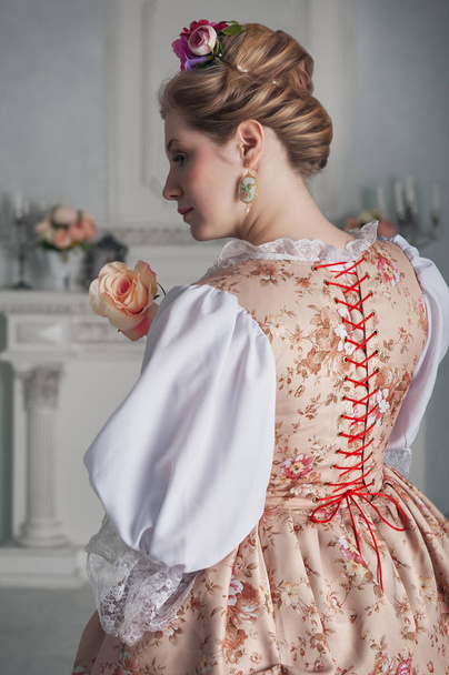 Beautiful woman in historic medieval dress. Back pose  - 写真・画像