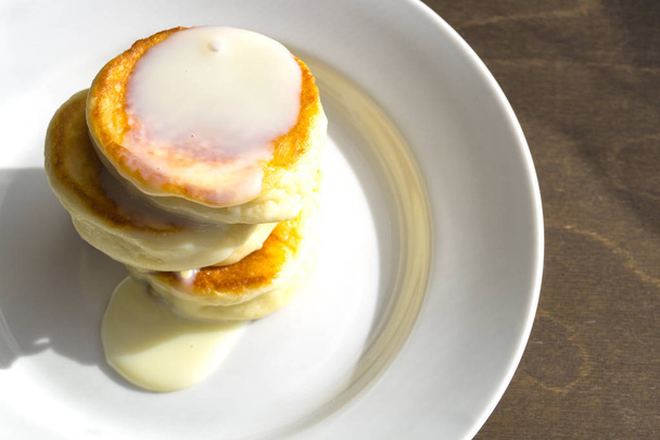 Pancake di fiocchi di latte su un piatto bianco. Colazione su un Sunny m
 - Foto, immagini