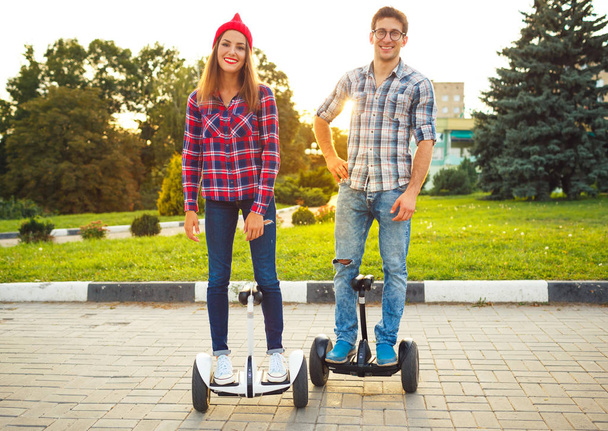 Pareja joven montando hoverboard - scooter eléctrico, personal ec
 - Foto, imagen