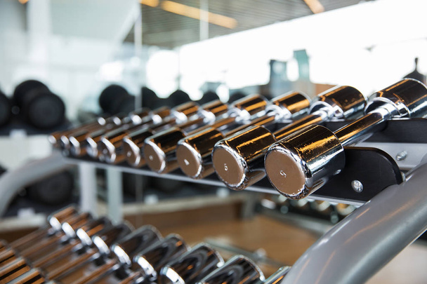 dumbbells and sports equipment in gym - Foto, immagini