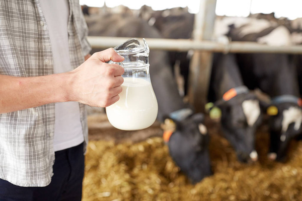 close up of man or farmer with milk on dairy farm - Foto, Imagen