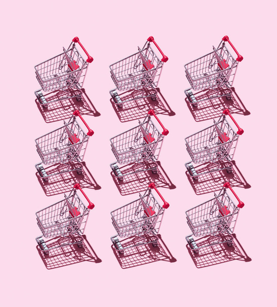 Carrinhos de compras sobre fundo rosa
 - Foto, Imagem