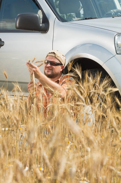 Farmer in sunglasses sitting near car - Fotografie, Obrázek