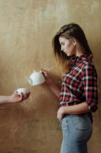 Pretty girl pouring tea to cup in male hand - Photo, image