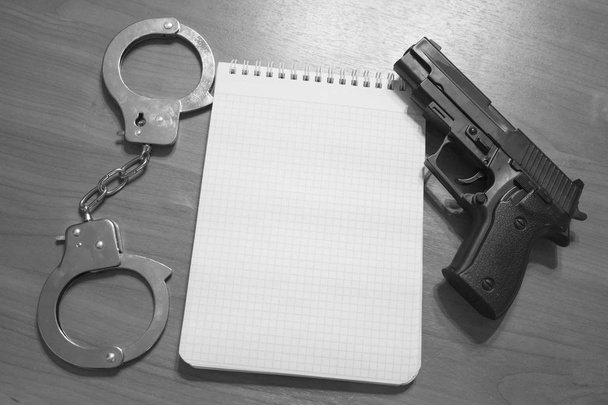 Handgun handboeien en Kladblok op de tafel met kopie ruimte zwart-wit fotografie - Foto, afbeelding