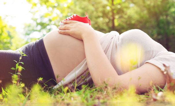 mulher grávida segurando sapatos de bebê  - Foto, Imagem