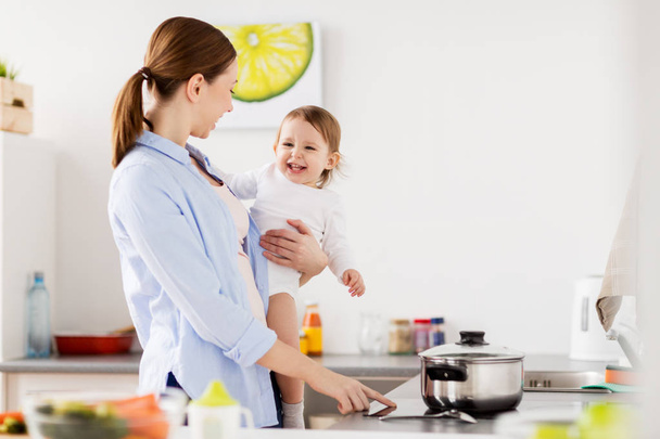 happy mother and baby cooking at home kitchen - Zdjęcie, obraz