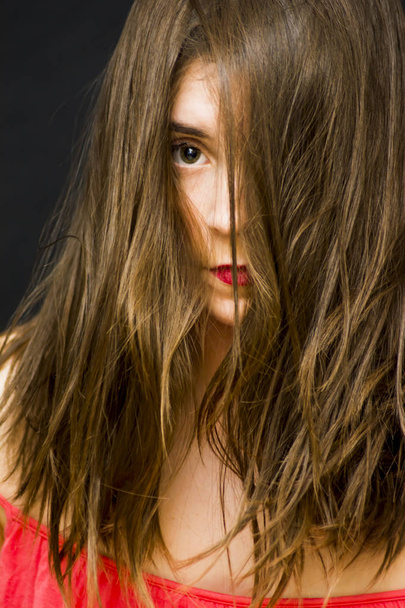 Portréja egy gyönyörű nő haját esett az arcán - Fotó, kép