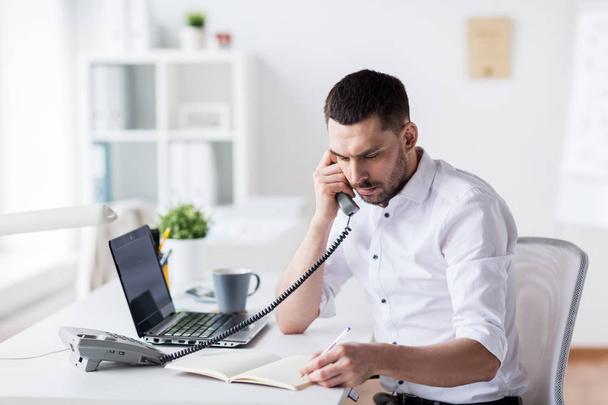 businessman with pad calling on phone at office - Φωτογραφία, εικόνα