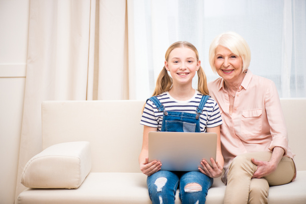 Girl with grandmother using laptop  - Photo, image