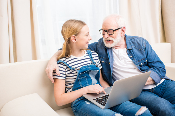 Girl with grandfather using laptop - Photo, Image