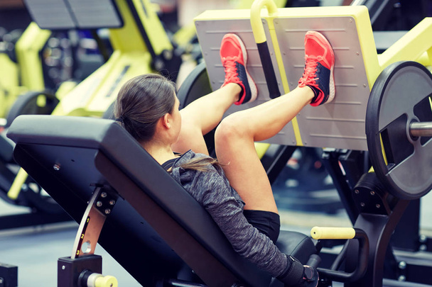woman flexing muscles on leg press machine in gym - Photo, Image