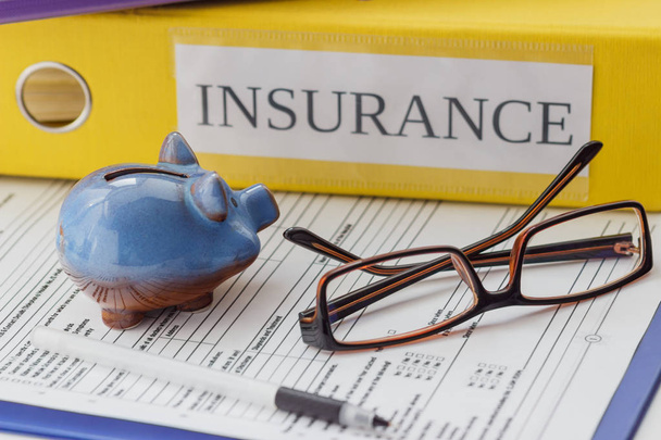 Clean insurance form, folders, pen, piggy bank and glasses - Foto, imagen