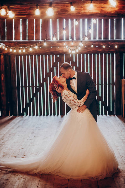 les jeunes mariés embrassant dans la grange rustique
 - Photo, image