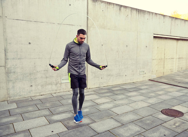 man exercising with jump-rope outdoors - Foto, afbeelding