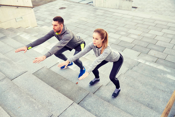 couple doing squats on city street stairs - Foto, Imagem