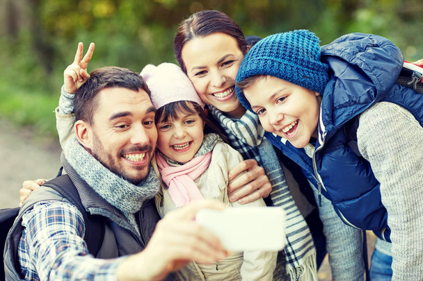 family taking selfie with smartphone in woods - Foto, Bild