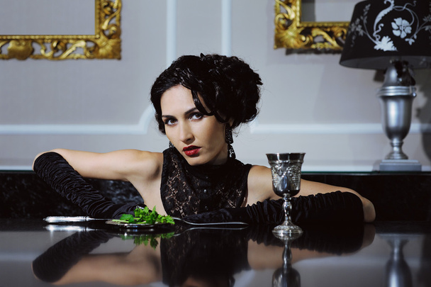 Элегантная ретро-женщина обедает в роскошном интерьере ресторана
 - Фото, изображение