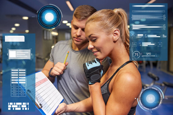 smiling woman with trainer and clipboard in gym - Foto, Imagem
