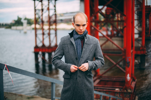 Köprü ve ceket düğmeleri, ciddi göz başarılı arka plan üzerinde duran genç iş adamı. soğuk rüzgarlı hava portre - Fotoğraf, Görsel