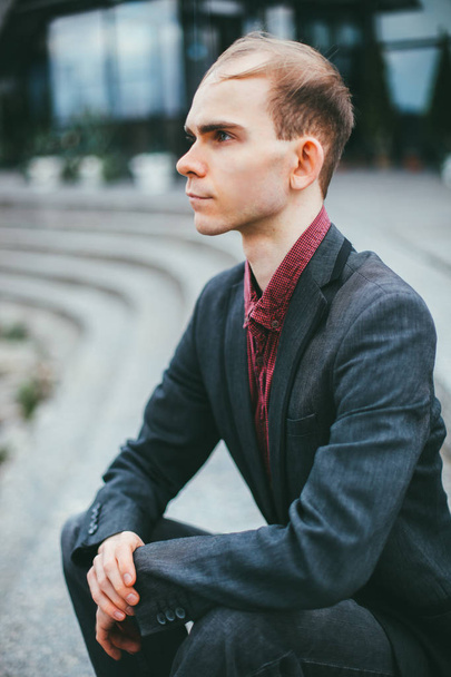 Portrait extérieur de jeune homme d'affaires chauve et beau en costume devant un bâtiment moderne. concept de voyage d'affaires
 - Photo, image