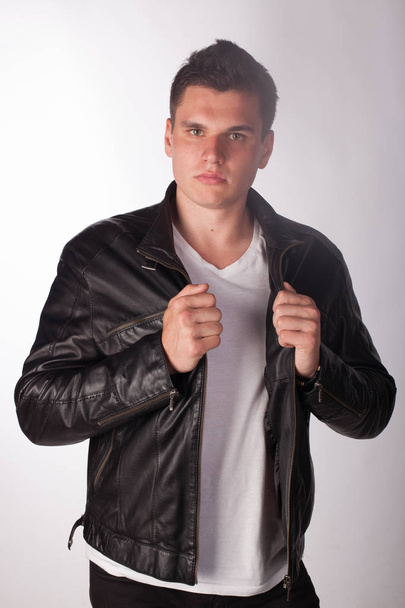 athletic man posing in the studio on a white background isolated in a black leather jacket - Foto, Imagem