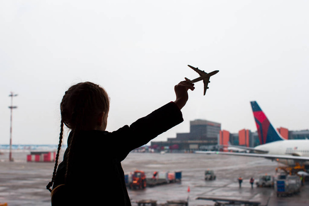 子供の手の空港の小さい飛行機模型のおもちゃの黒いシルエット - 写真・画像