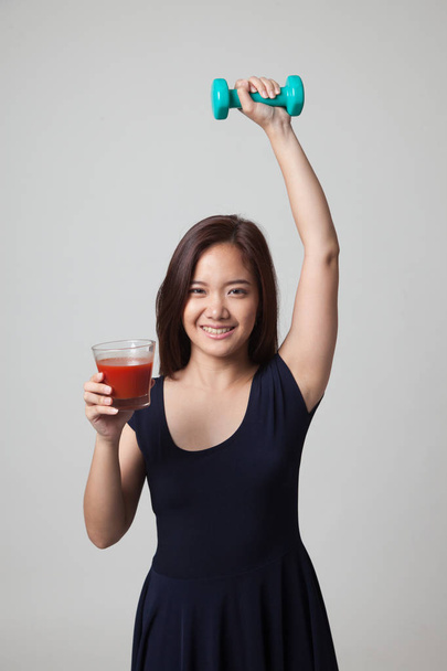 Healthy Asian woman with dumbbell and  tomato juice. - Fotó, kép