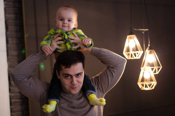 Père câliner son fils à côté d'une lampe en forme d'ampoules, discret, fameux
 - Photo, image