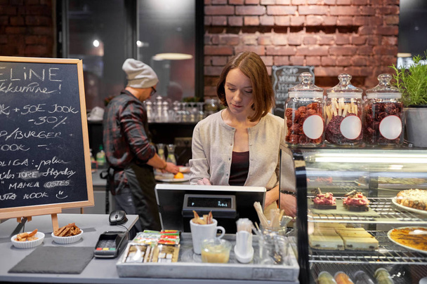 woman or barmaid with cashbox at cafe - Фото, зображення