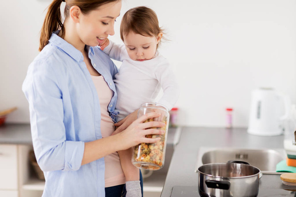 mother and baby cooking pasta at home kitchen - Foto, immagini