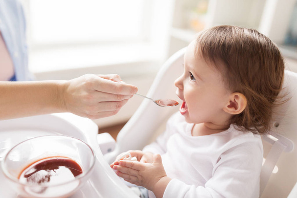 mother feeding baby with puree at home - Fotoğraf, Görsel