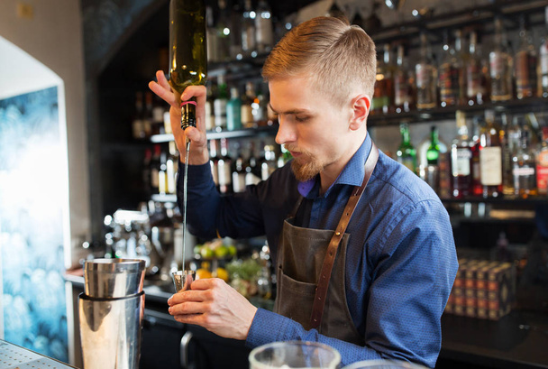 barman with shaker preparing cocktail at bar - Фото, изображение