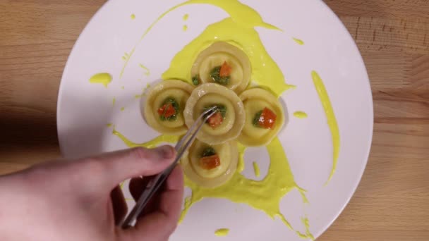 Esteticky krásné servírovací nádobí. Kuchař dá snítkou zelené na ravioli, použití pinzety. Dekorace pokrm v restauraci před podáváním - Záběry, video