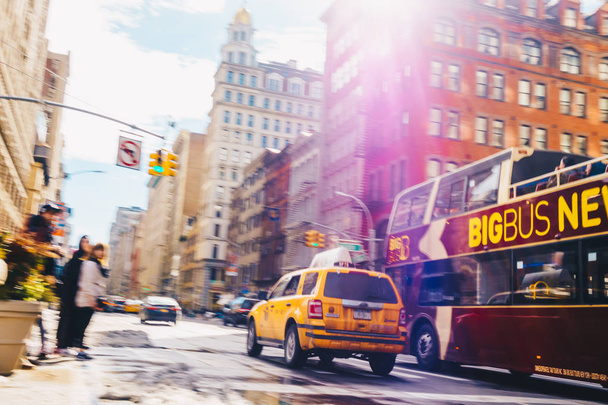 Нью-Йорк - 20 марта 2017 года: Жёлтое такси едет вниз на Нью-Йорк-стрит. Выстрел с большой скоростью затвора для намеренного размытия движения
. - Фото, изображение