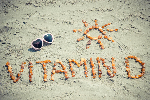Sunglasses, inscription vitamin D and shape of sun on sand at beach, summer time and healthy lifestyle - Фото, зображення