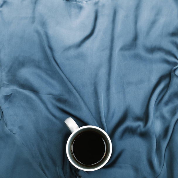White mug on blue cloth - Φωτογραφία, εικόνα