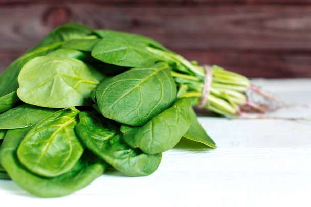 A bouquet of fresh spinach on a wooden table - Photo, Image