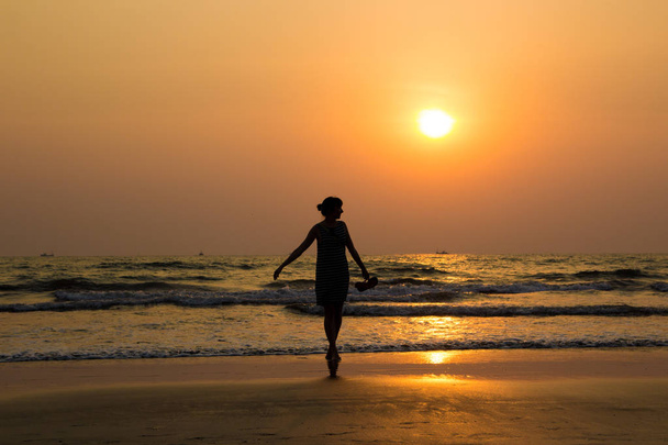 Σιλουέτα του μια όμορφη νεαρή κοπέλα στην Ινδία, Γκόα, Ar ηλιοβασίλεμα - Φωτογραφία, εικόνα