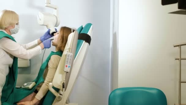 Cyfrowy sprzęt dentystyczny badania diagnostycznego z kobietą pacjenta w odzież ochronną 4k - Materiał filmowy, wideo