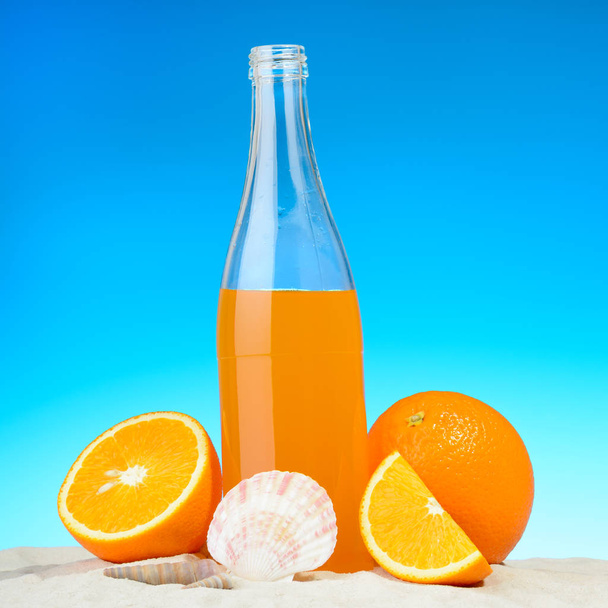 Az üveg, a narancslé és a gyümölcsök, a strandon - Fotó, kép