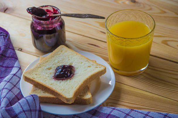 Ontbijt blueberr jam, toast, koffie en sinaasappelsap - Foto, afbeelding
