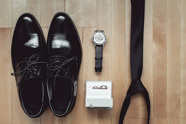 Close up de acessórios modernos do noivo. alianças de casamento, gravata preta, sapatos de couro e assistir
 - Foto, Imagem