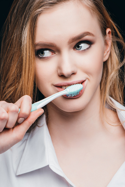 woman in male shirt brushing teeth - Zdjęcie, obraz