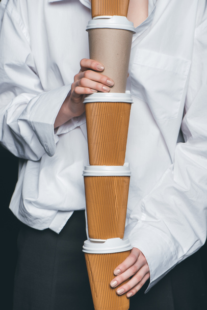 Woman holding pile of disposable coffee cups - Fotó, kép