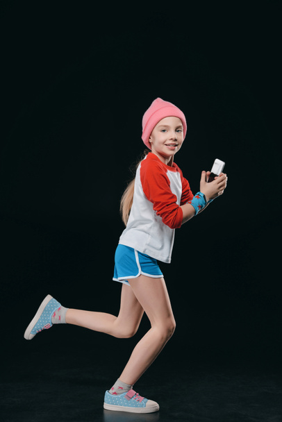 chica en ropa deportiva usando teléfono inteligente
 - Foto, Imagen